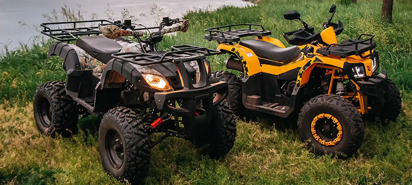 2 ATVs on grass by a lake without people