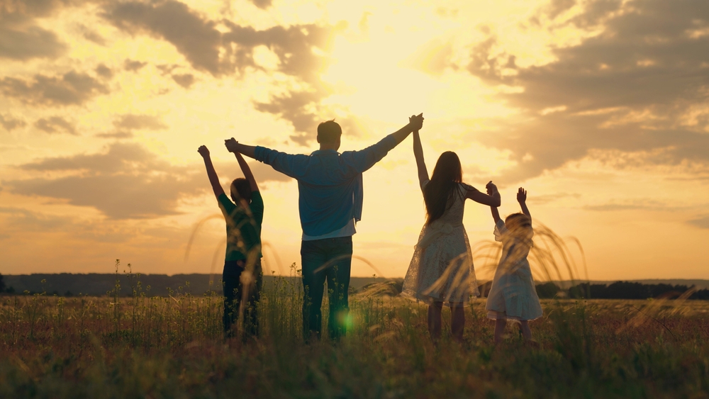 Family in field at sunset