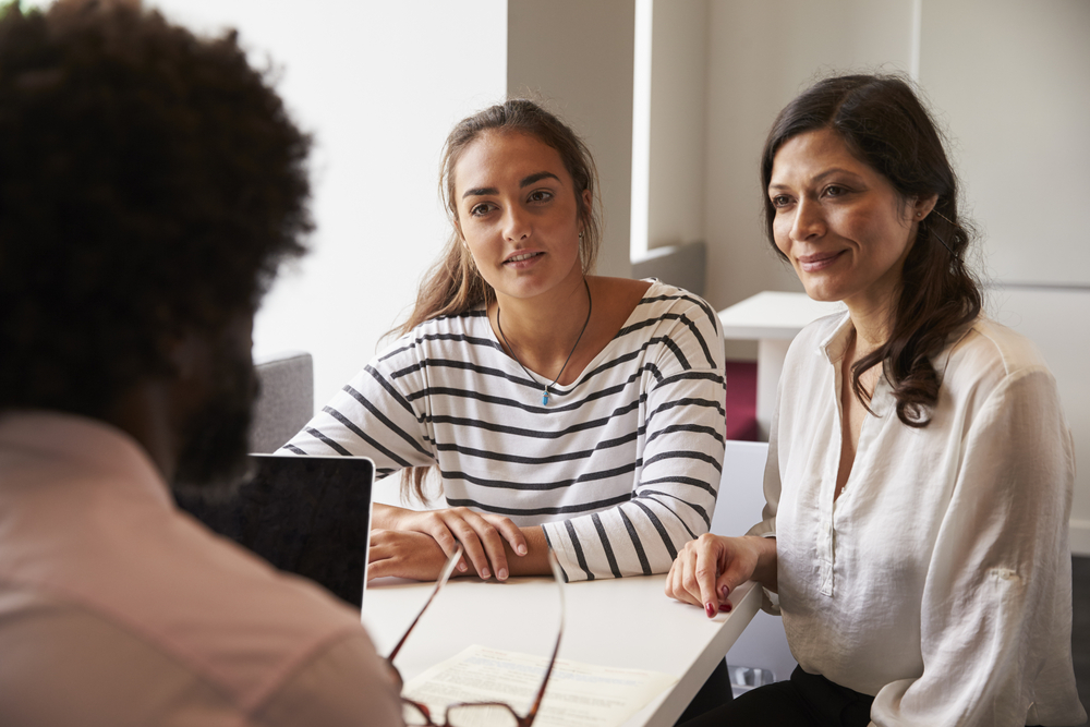 Mother and daughter speaking with college advisor