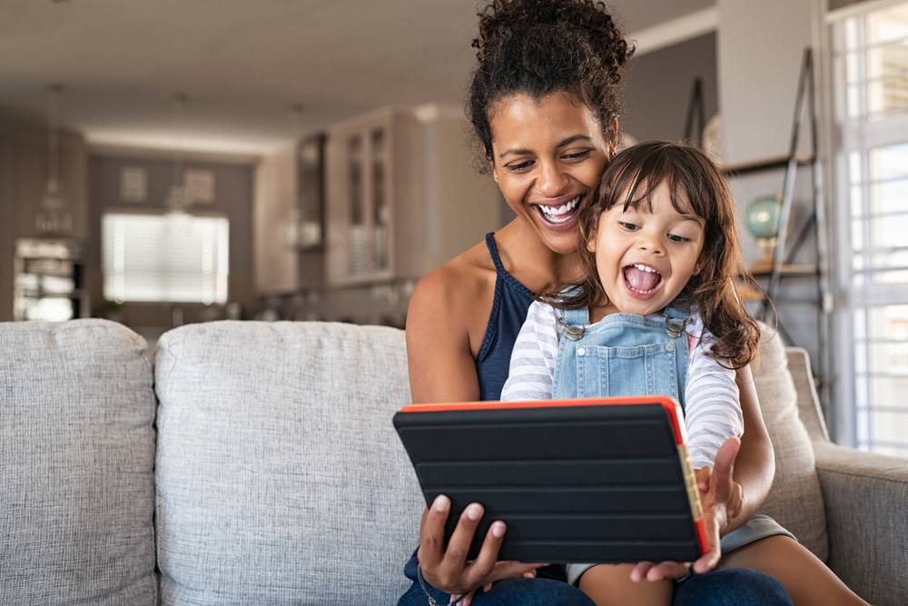 Mother and young daughter looking at tablet.