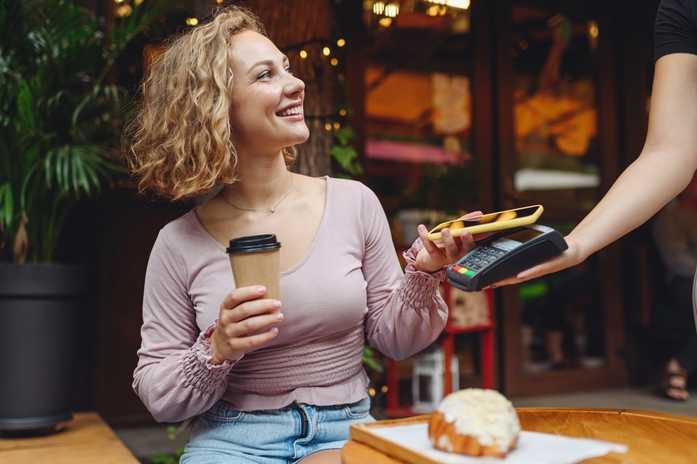 Woman paying for a coffee with a card.