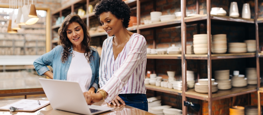 Two small business owners using a laptop computer.