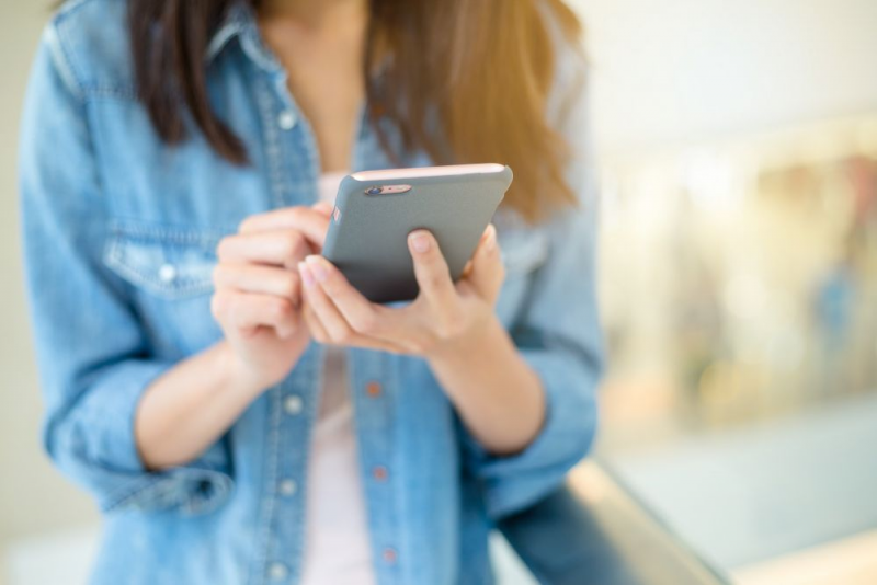 Image of hands holding a mobile phone.