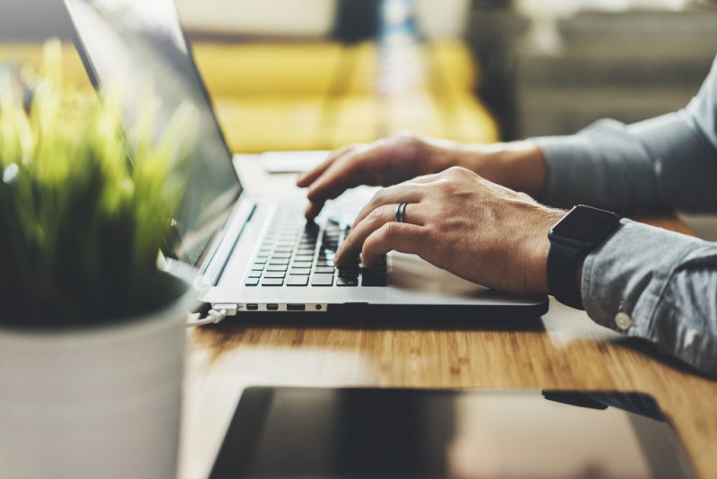 Close up of hands on a laptop computer.